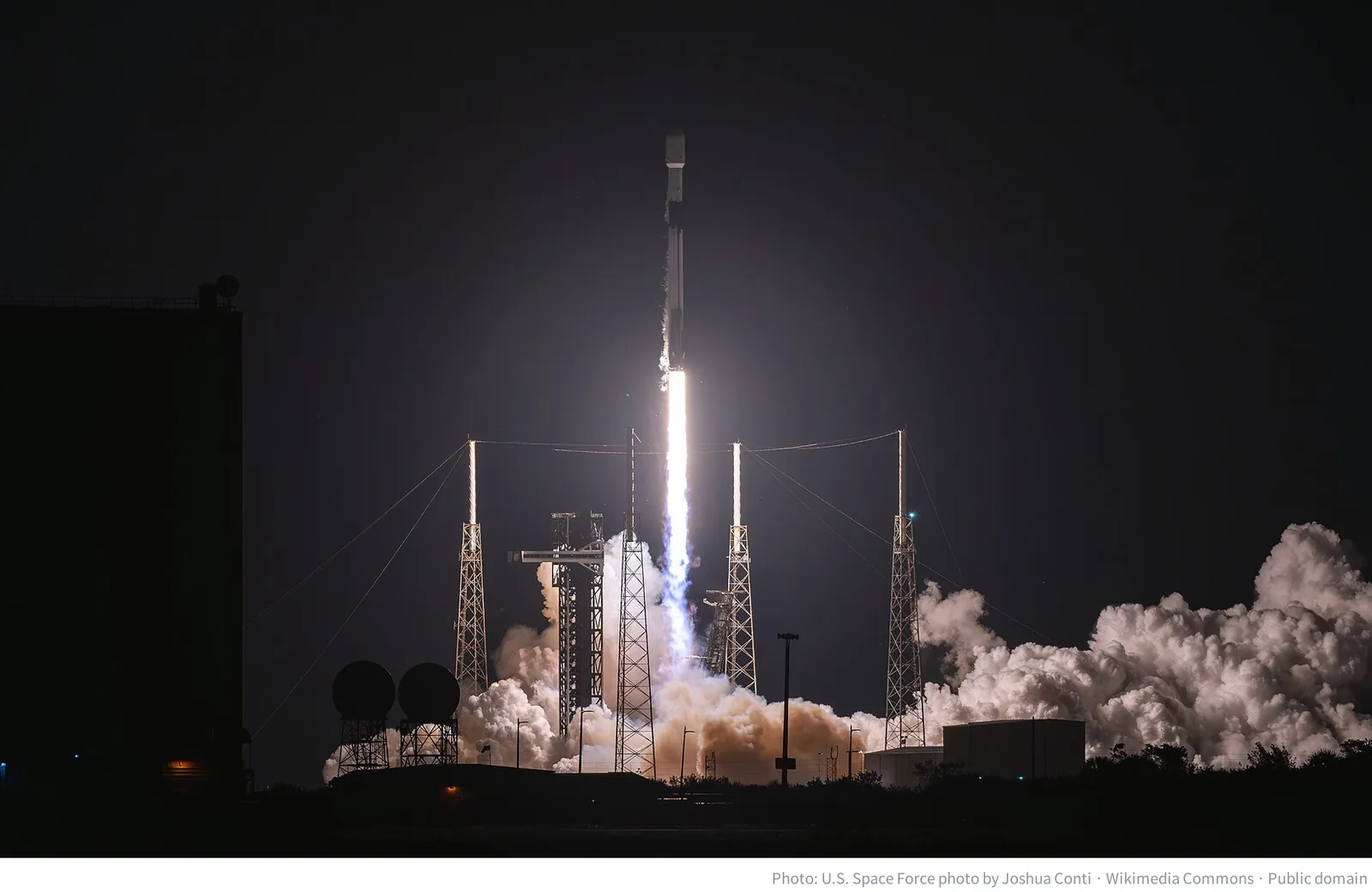 A Falcon 9 rocket carrying Starlink satellites lifting off from Cape Canaveral at night