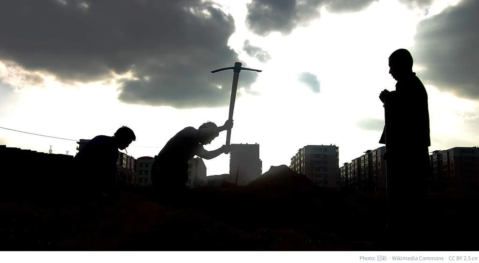 Silhouettes of Chinese migrant construction workers against the sky