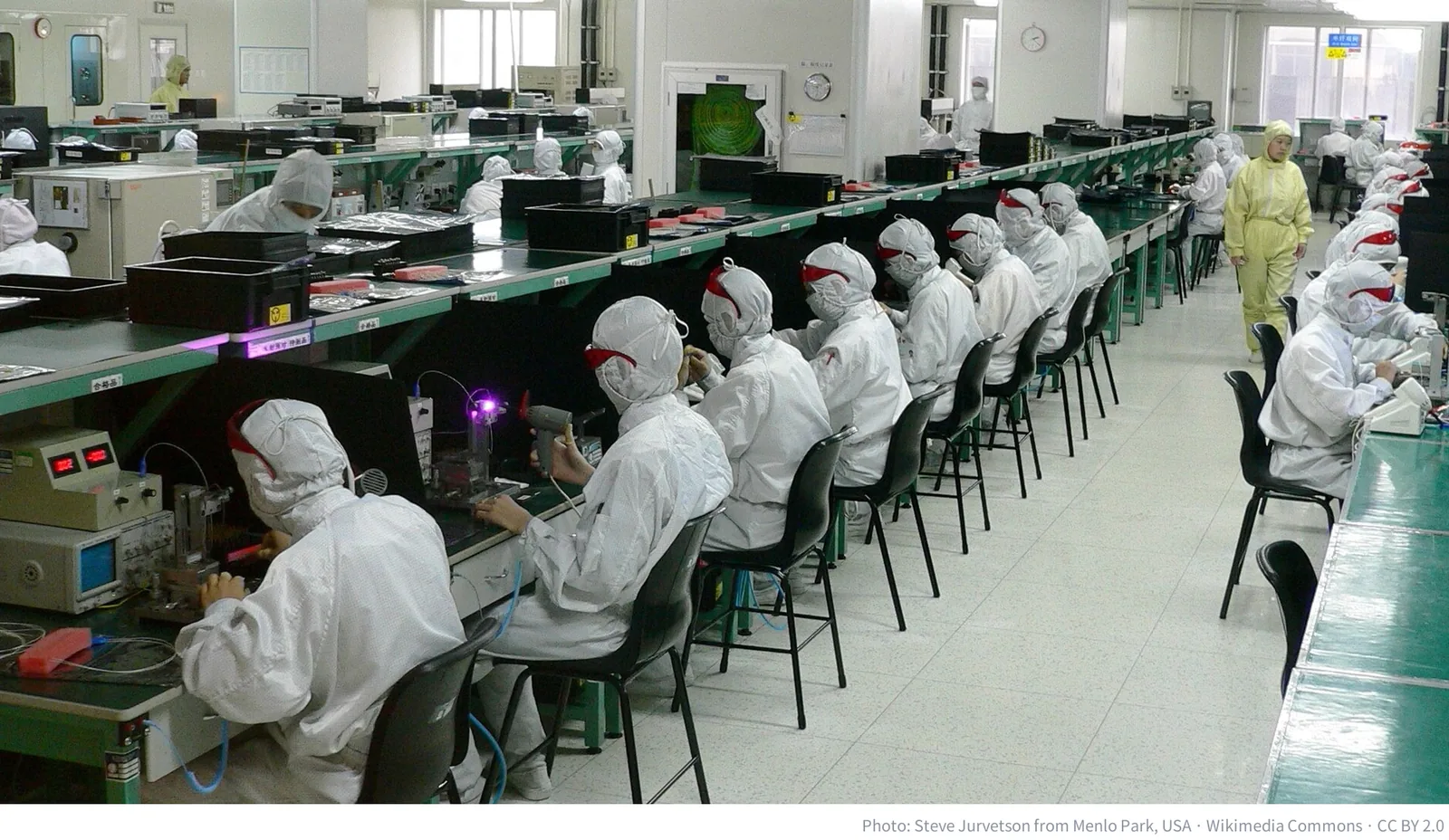 Workers in protective suits assembling electronics at a factory in Shenzhen, China
