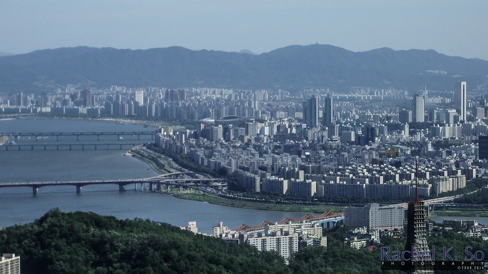 I am at the observatory for N-Seoul Tower, about 350 meters over the city. I have a good view of some modern-day developments on the southern side of Seoul, inc