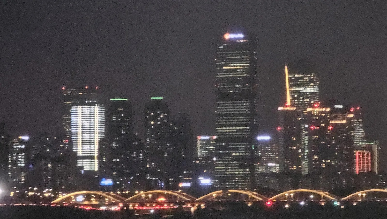 Night view of Yeouido's lit skyscrapers in Seoul across the Han River, seen from Dongjak Bridge.