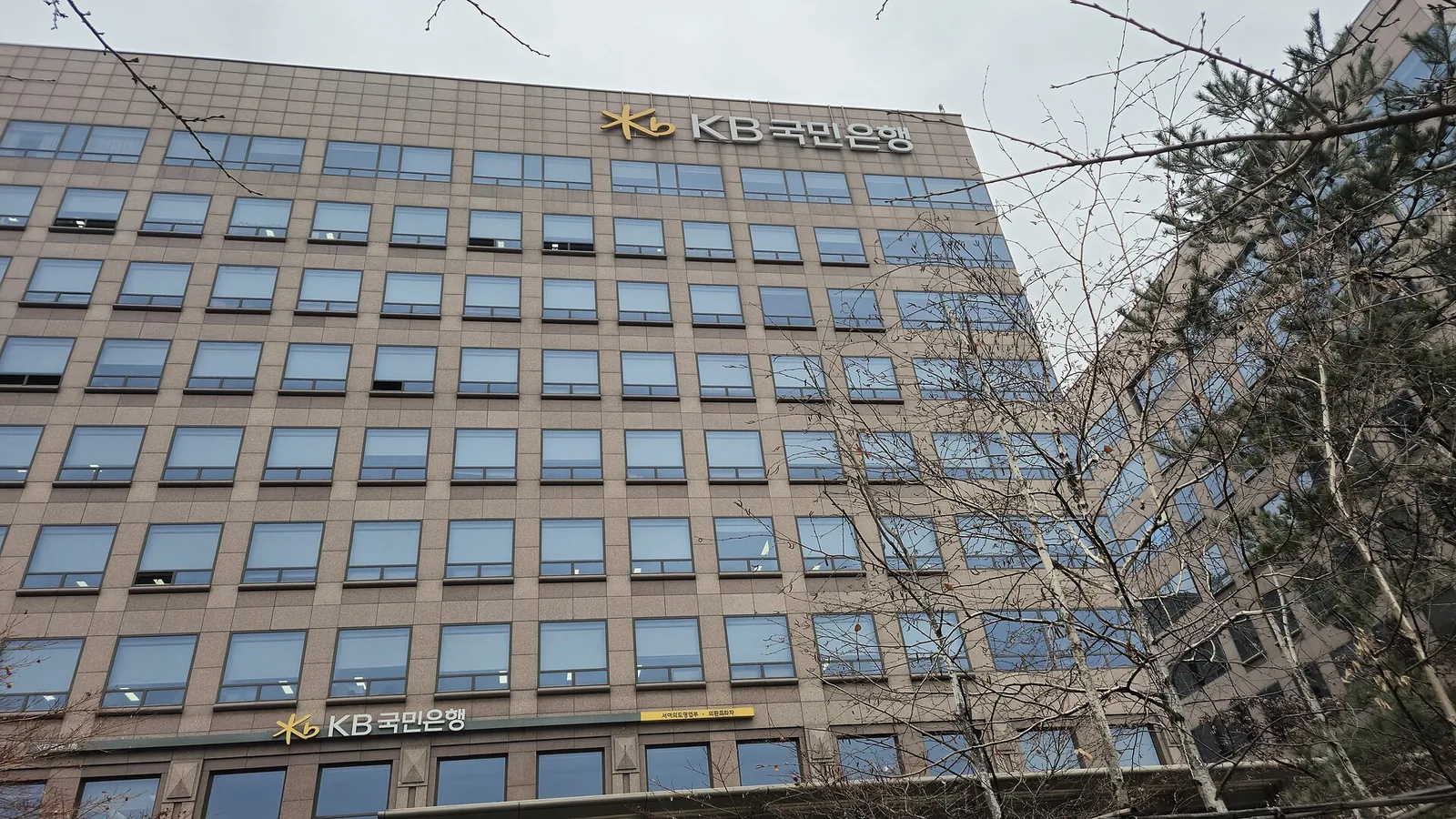 KB Kookmin Bank West Yeouido office building in Seoul with the KB Kookmin Bank logo on its facade.