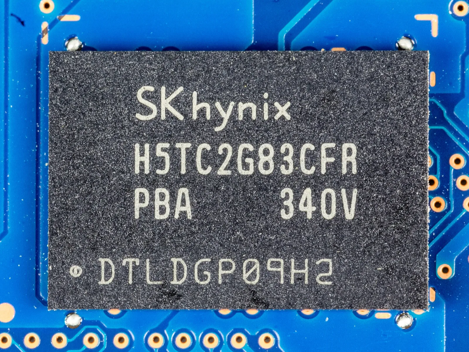 Close-up of an SK hynix H5TC2G83CFR DDR3L DRAM chip on a blue circuit board, with the SK hynix logo printed on top.