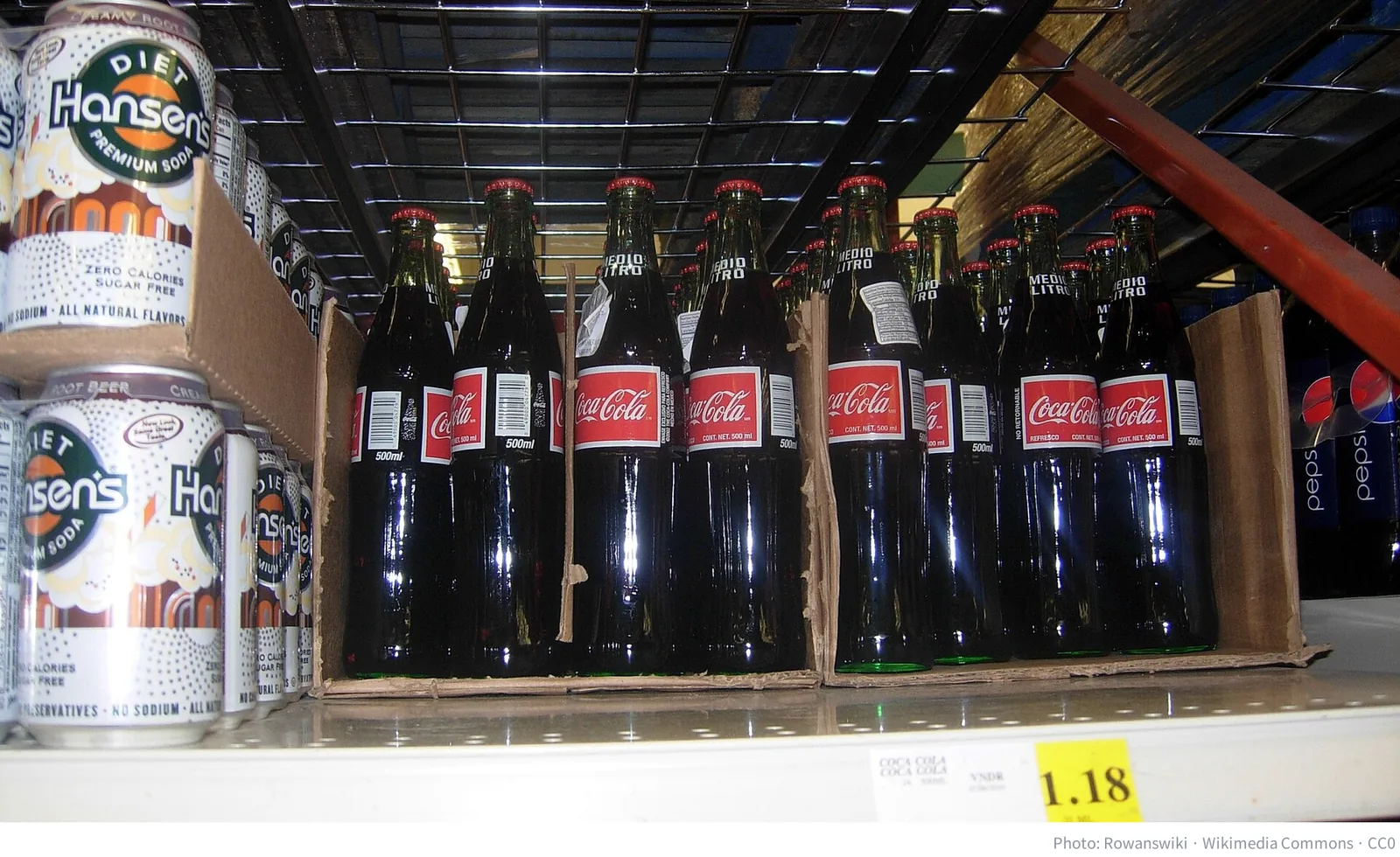 Coca-Cola bottles on a grocery store shelf